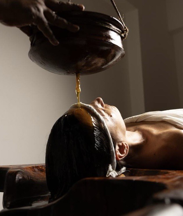 Shiro Dhara — warm oil poured in a steady stream across the forehead